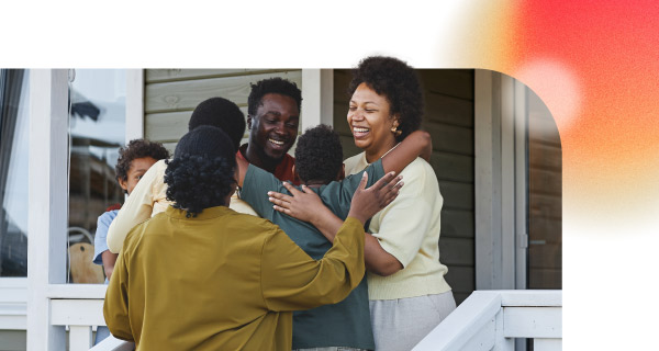 A large family embracing on the front porch of their home.